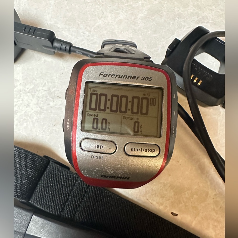 Garmin running/fitness tracker and telemetry strap with charger.